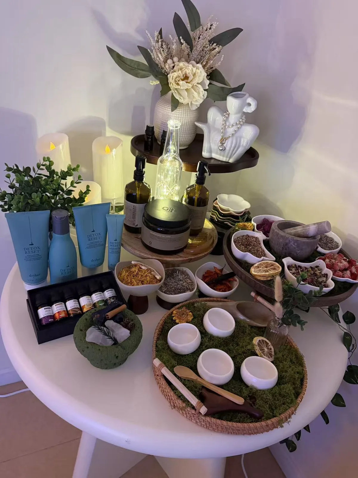 Botanical scalp-care products, candles, oils and dried herbs arranged on a table at Jinyue Head Spa in Flushing
