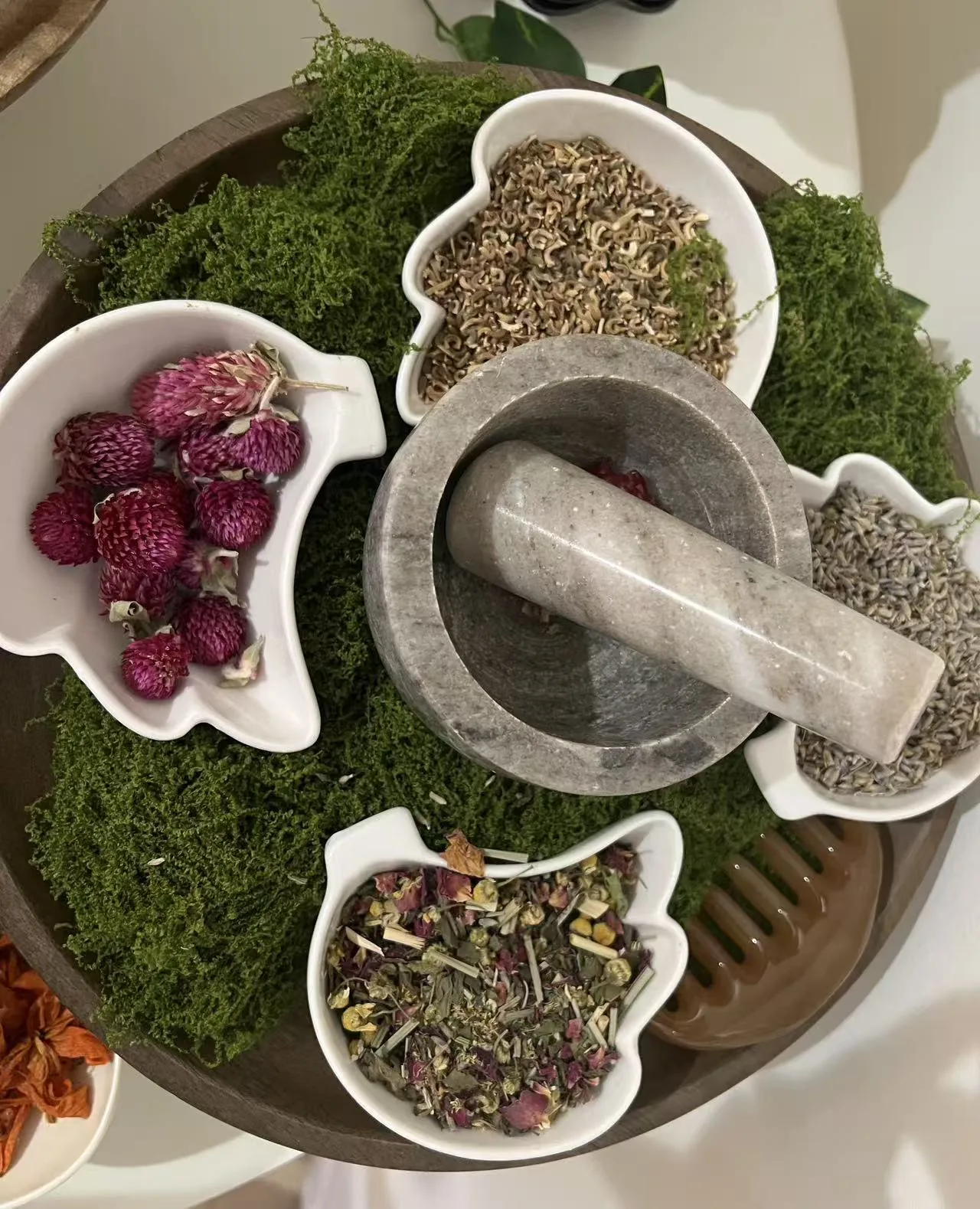 Stone mortar and pestle with bowls of dried flowers at Jinyue Head Spa