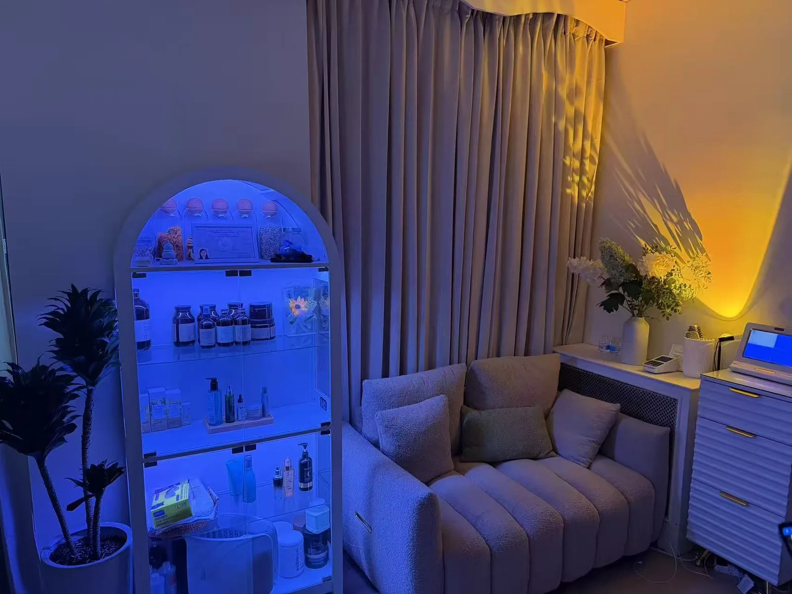 Illuminated product cabinet beside a bouclé sofa inside Jinyue Head Spa