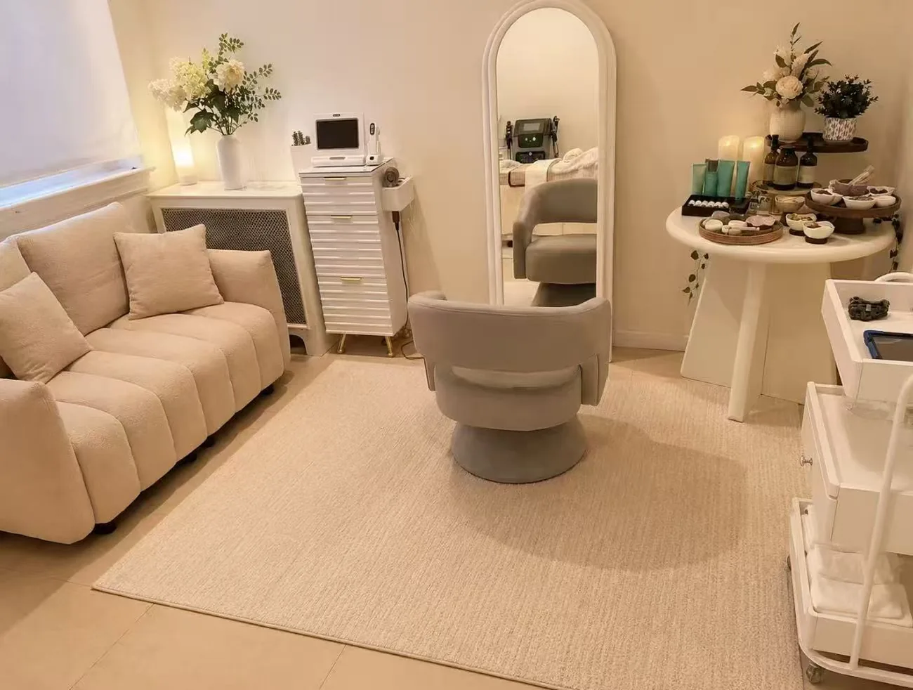 Bright studio lounge with bouclé sofa, mirror and product table at Jinyue Head Spa in Flushing